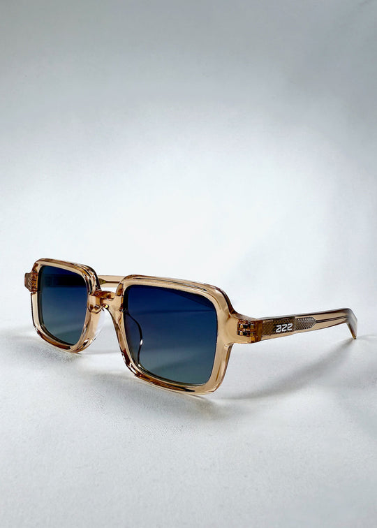 Angled front view of Draxen - Amber Frost sunglasses showing soft brown acetate frame and Aze logo on the temple. 