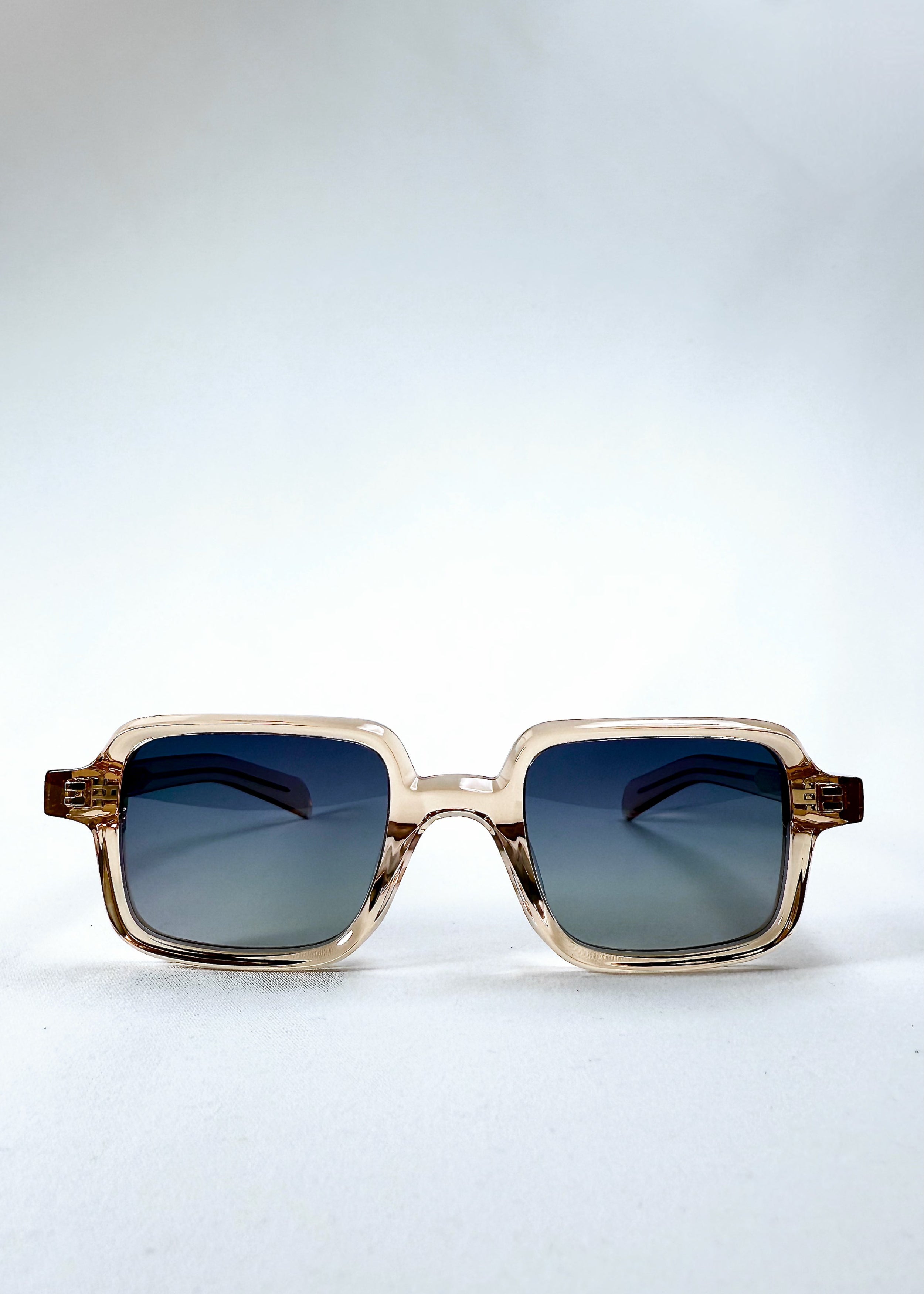 Front view of Draxen sunglasses in Amber Frost with rectangular frame and gradient blue lenses.  