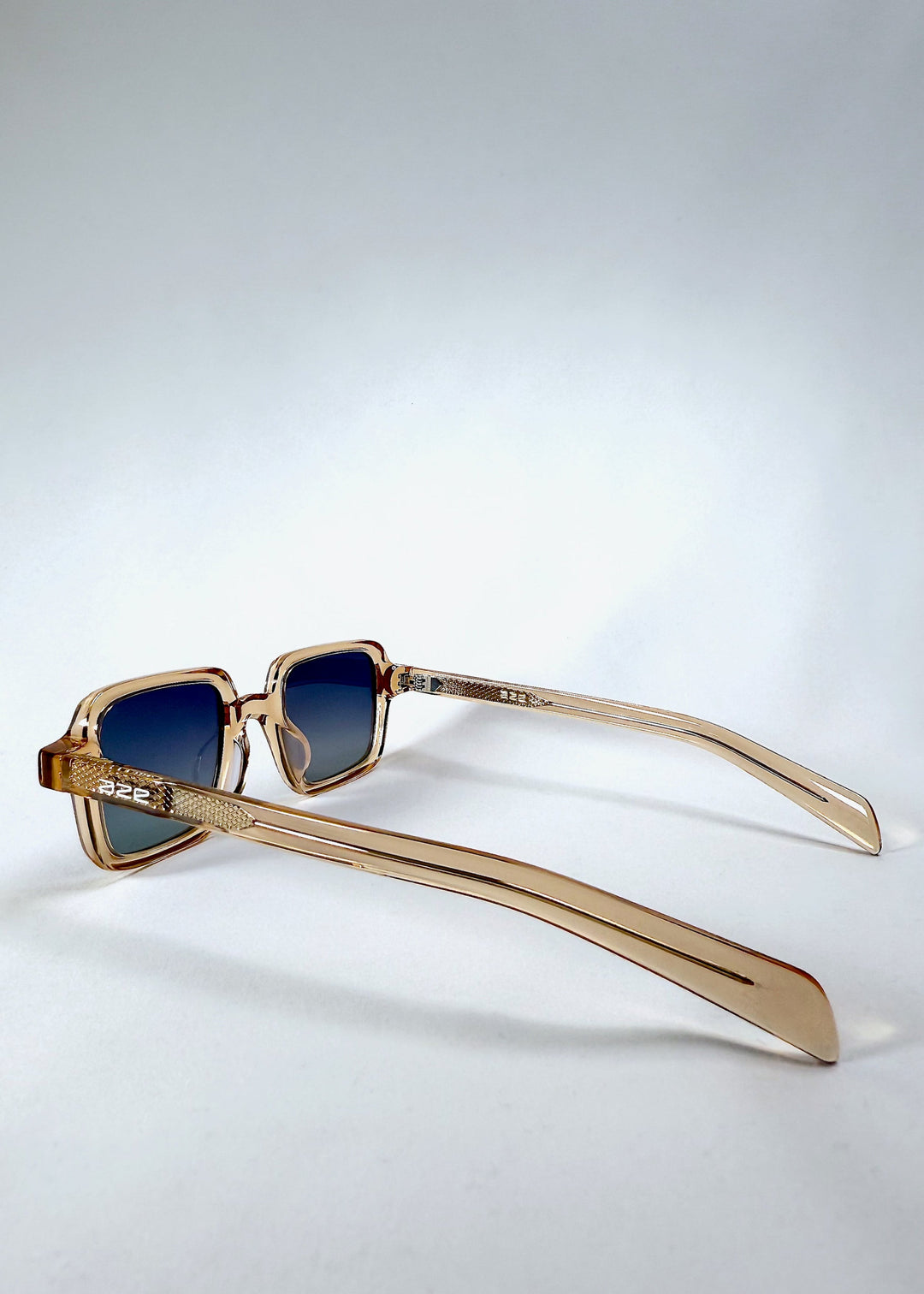 Side view of Draxen - Amber Frost sunglasses showing slim curved temple and metallic accent pattern. 