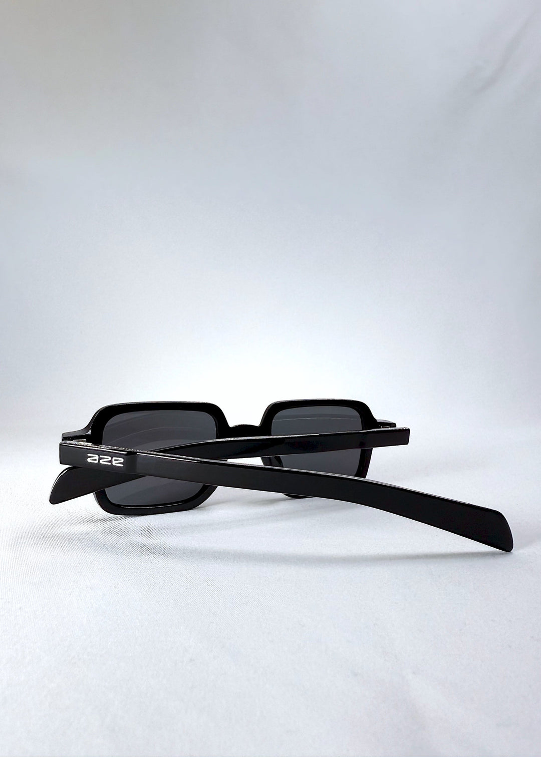 Folded side view of Draxen sunglasses in Obsidian Black with the AZE logo visible on the temples. 