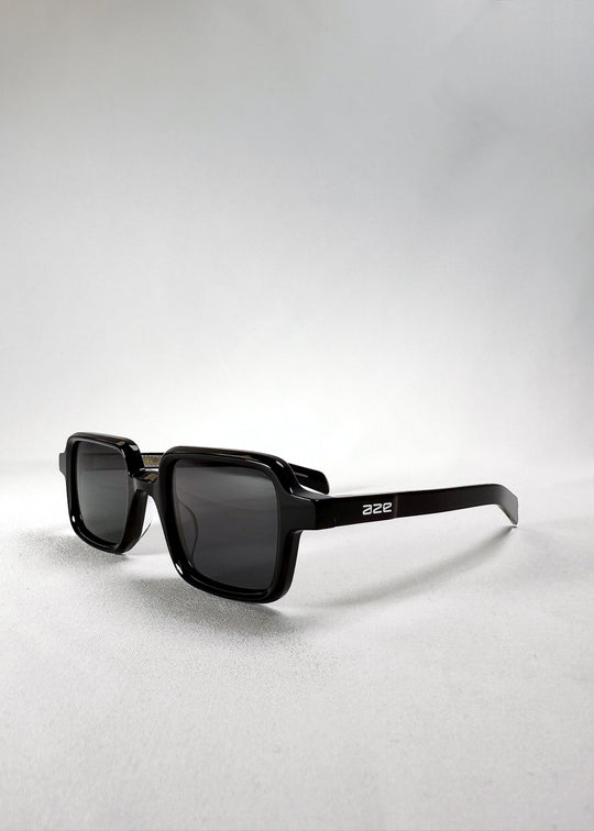 Front angle view of Draxen sunglasses in Obsidian Black showing the Aze logo on the temple and the compact silhouette. 
