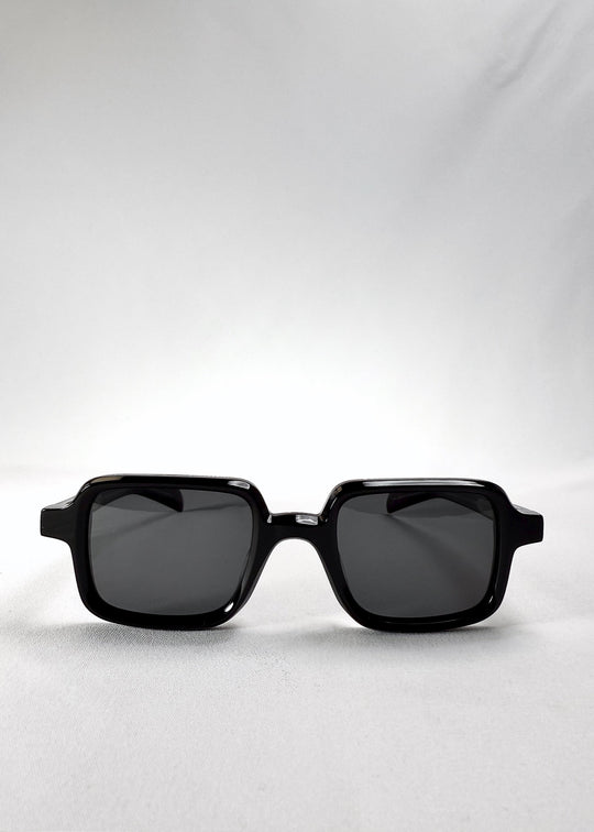 Front view of Draxen sunglasses in Obsidian Black, featuring a petite rectangular acetate frame and dark polarized lenses. 