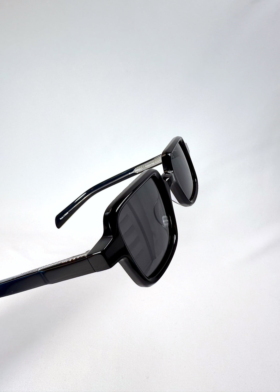 Close-up of the Draxen frame in Obsidian Black, highlighting the hinge construction and glossy acetate finish. 