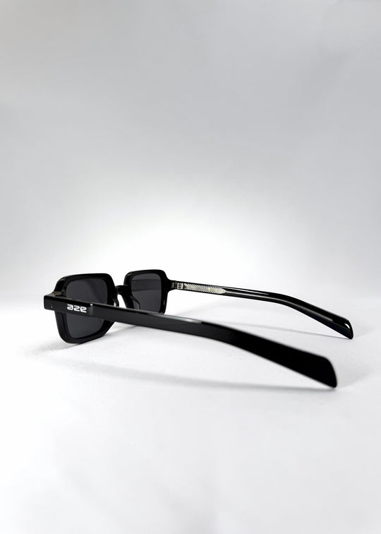 Side temple view of Draxen sunglasses in Obsidian Black, showcasing the slender acetate arms and engraved hinge detail. 