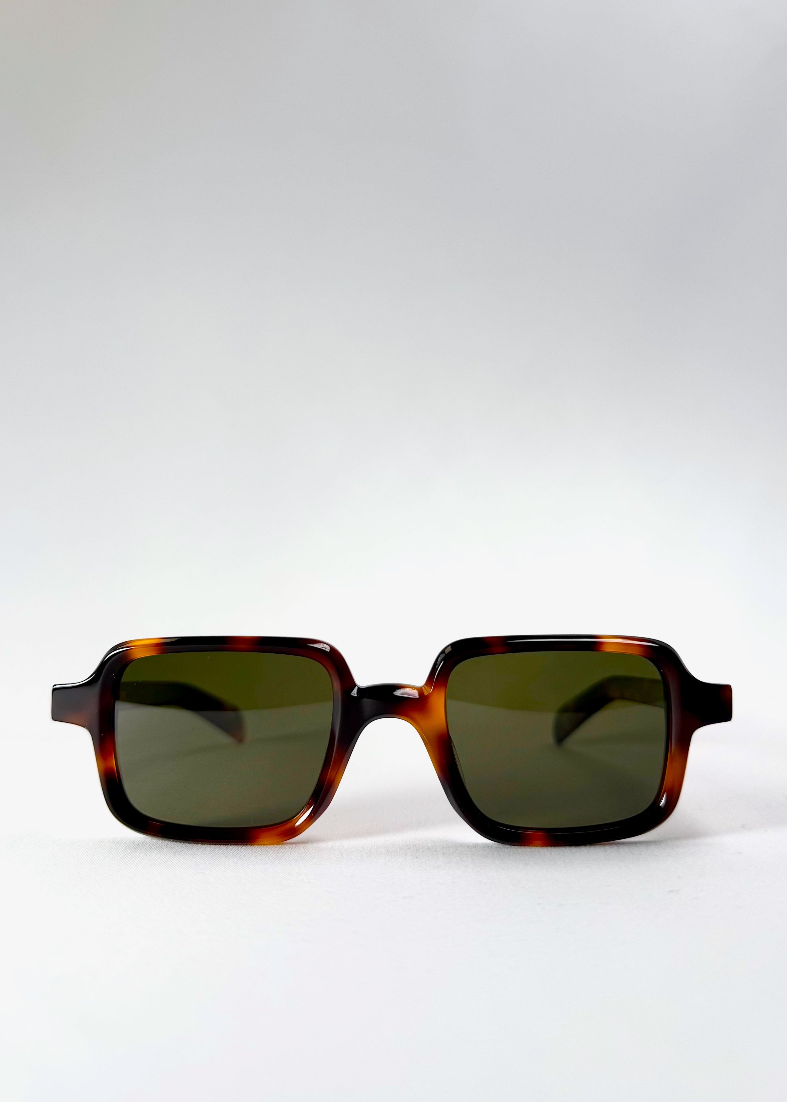 Front view of Draxen sunglasses in tortoiseshell, showing the symmetrical rectangular frame and green-tinted lenses. 