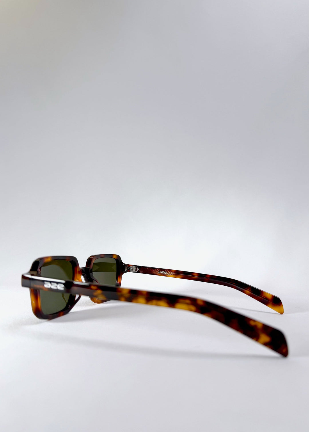 Side view of Draxen tortoiseshell sunglasses, displaying the acetate arms and engraved Aze logo. 