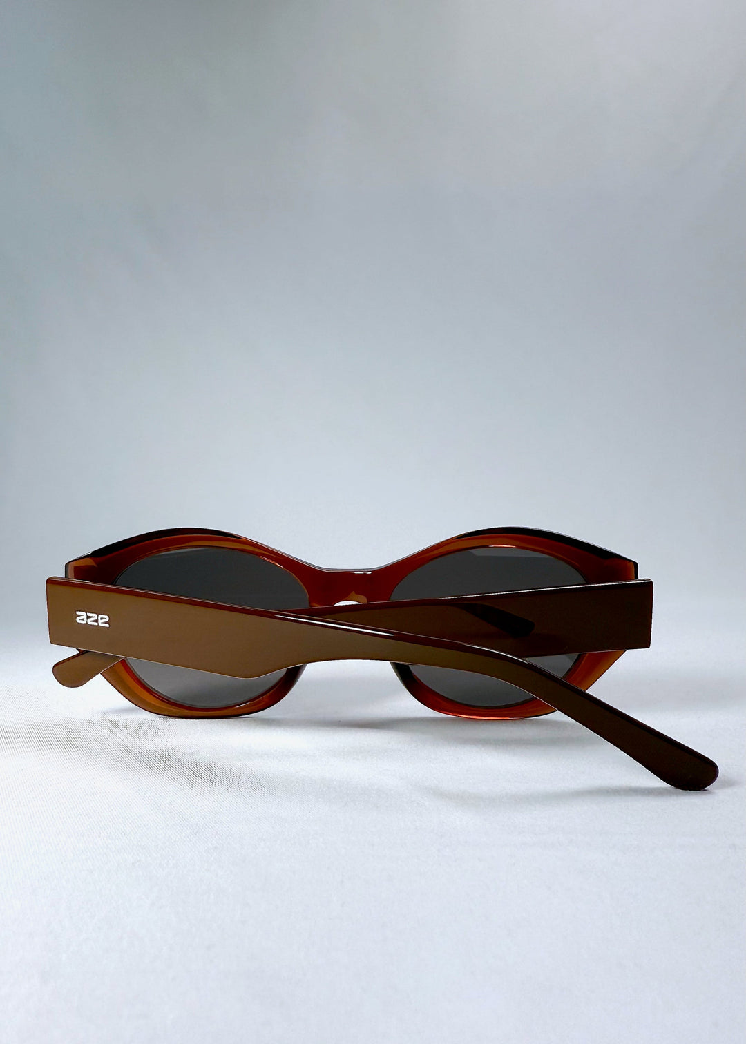 Folded Eclipse Feline sunglasses in Burnished Umber seen from the back, with clean hinge lines and signature temple finish. 
