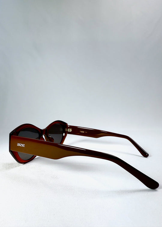 Side profile of Burnished Umber Eclipse Feline sunglasses, showcasing sculpted acetate temples and logo detail. 
