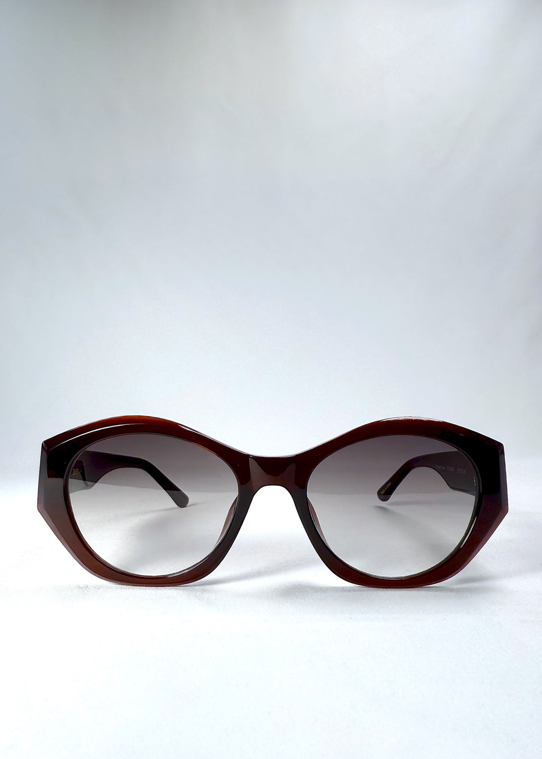 Front view of Eclipse Feline in Crimson Mirage with translucent wine-red acetate frame and gradient nylon lenses. 