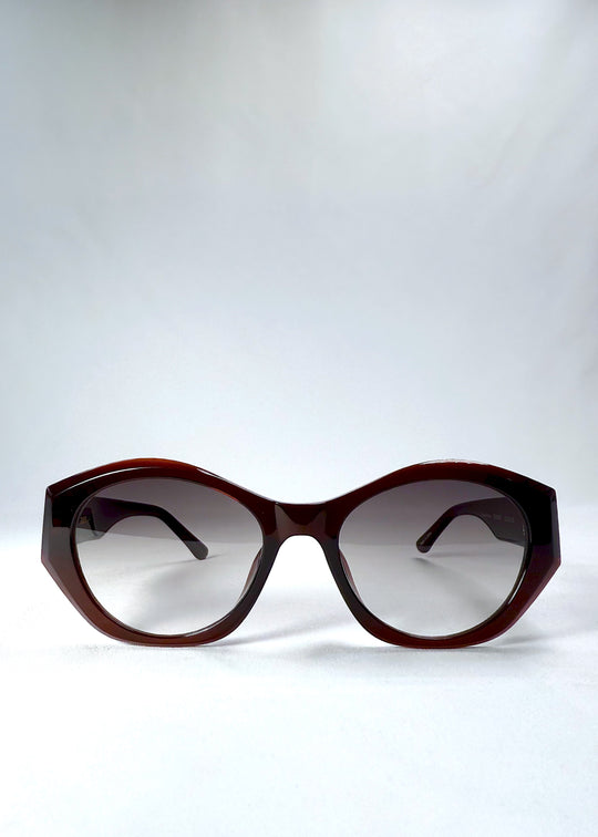 Front view of Eclipse Feline in Crimson Mirage with translucent wine-red acetate frame and gradient nylon lenses. 