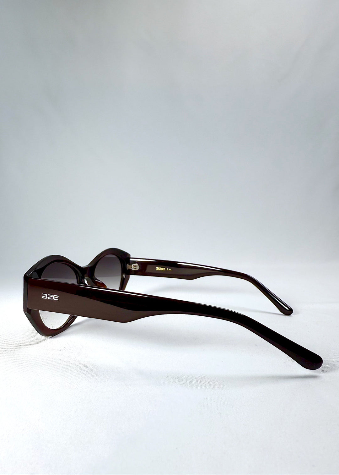 Side view showcasing the wide temple arms and clean profile of the Eclipse Feline Crimson Mirage sunglasses. 