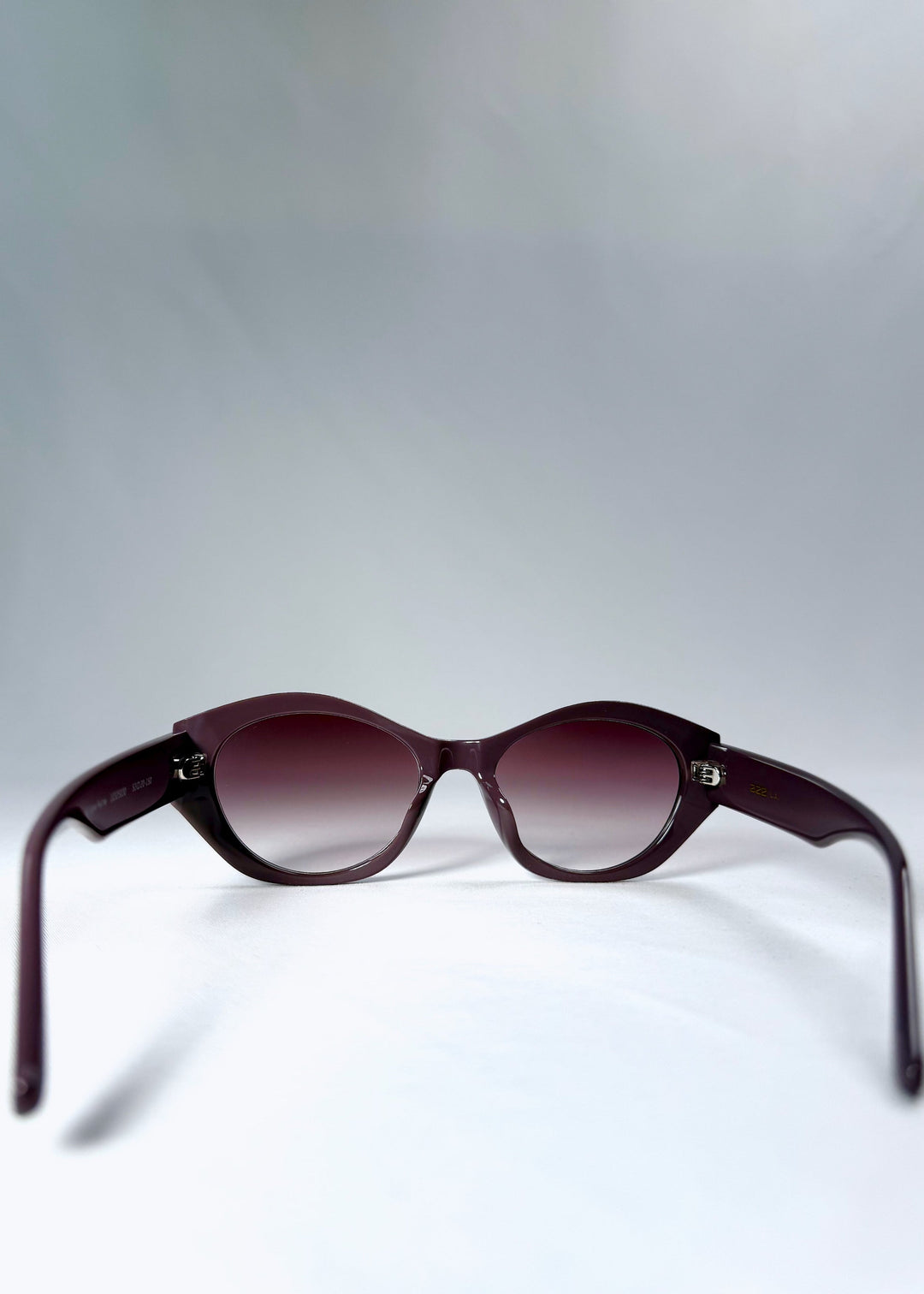 Back view of Eclipse Feline - Twilight Plum sunglasses, showing curved acetate arms and fixed hinges. 