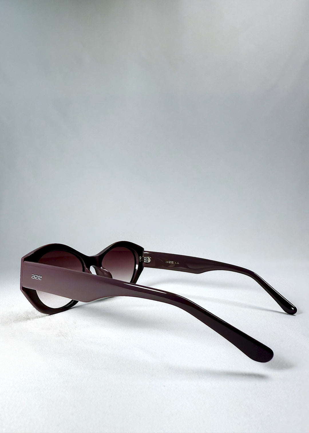 Side view of Eclipse Feline - Twilight Plum with wide sculpted temples and translucent plum finish.