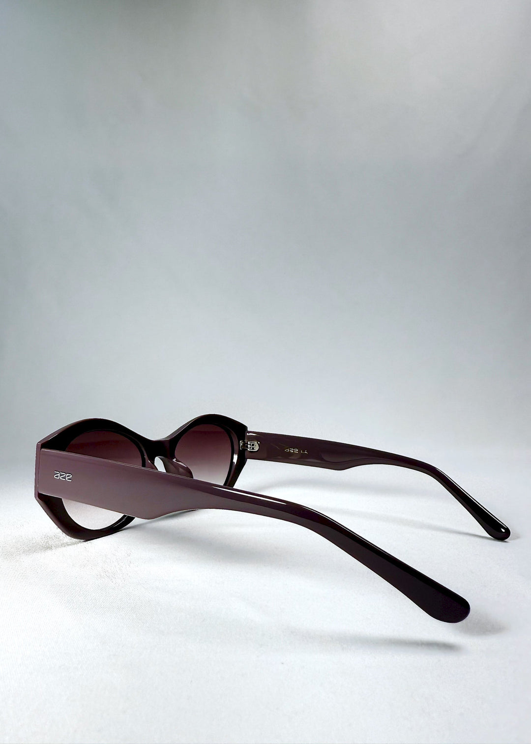 Side view of Eclipse Feline - Twilight Plum with wide sculpted temples and translucent plum finish. 