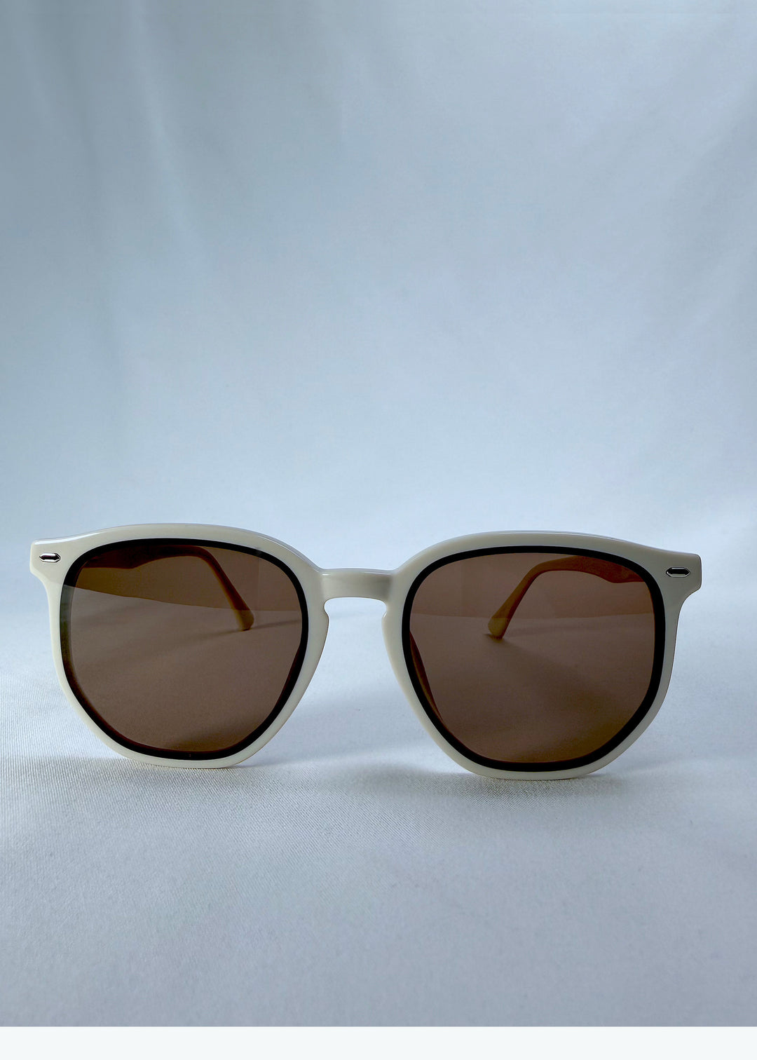 Front view of Elara sunglasses in Creamy Beige, featuring creamy beige acetate frame and warm brown lenses, showing the full front silhouette.