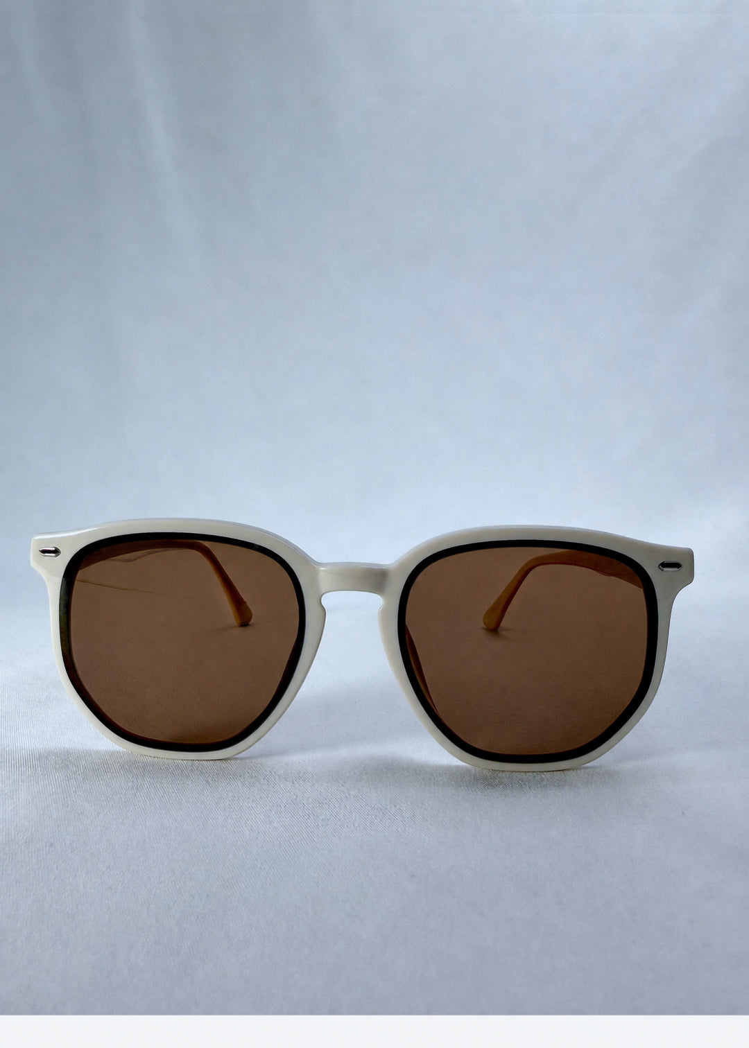 Front view of Elara sunglasses in Creamy Beige, featuring creamy beige acetate frame and warm brown lenses, showing the full front silhouette.