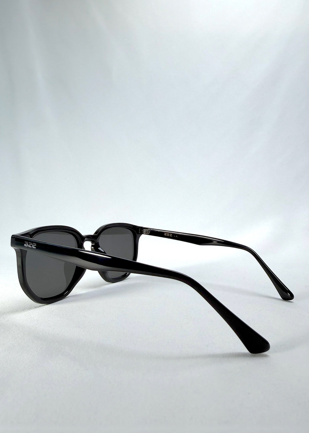 Back-angle view of Elara sunglasses in Obsidian Black, featuring black acetate frame and dark lenses, showing the back structure and temple alignment. 