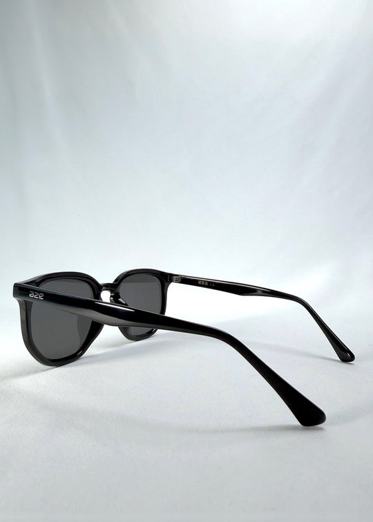 Back-angle view of Elara sunglasses in Obsidian Black, featuring black acetate frame and dark lenses, showing the back structure and temple alignment. 