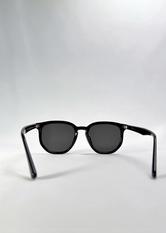 Back view of Elara sunglasses in Obsidian Black, featuring black acetate frame and dark lenses, showing the inside frame and open temples. 