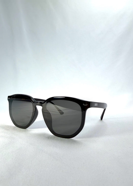 Three-quarter front view of Elara sunglasses in Obsidian Black, featuring black acetate frame and dark lenses, showing the front shape and temple profile.