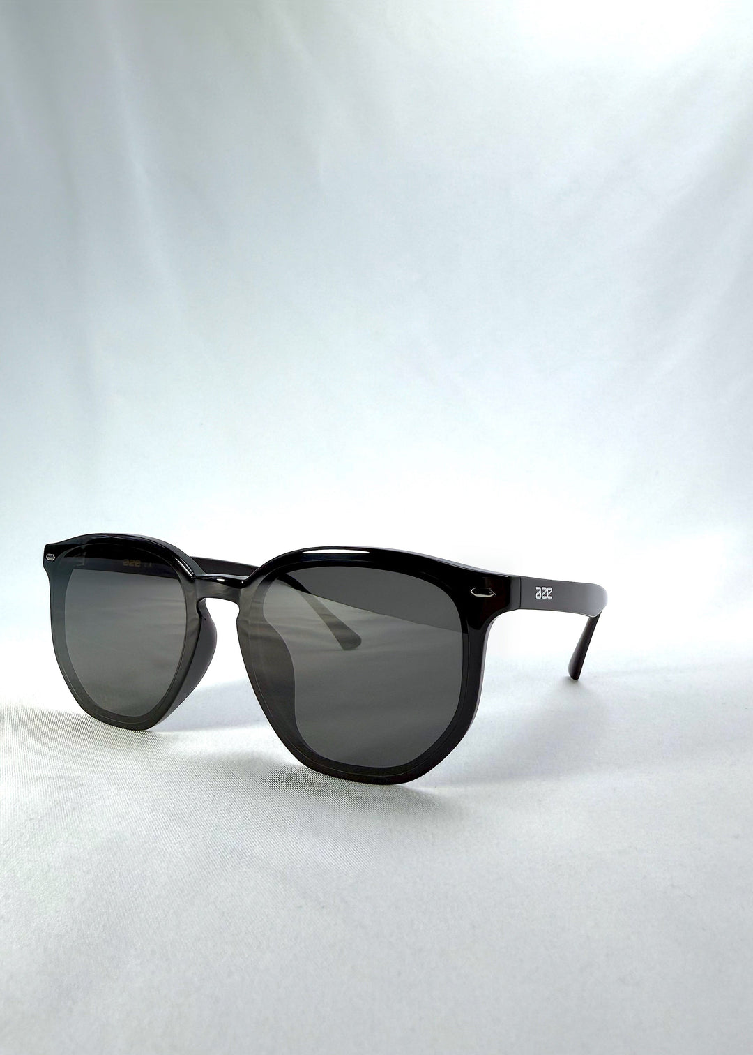 Three-quarter front view of Elara sunglasses in Obsidian Black, featuring black acetate frame and dark lenses, showing the front shape and temple profile. 