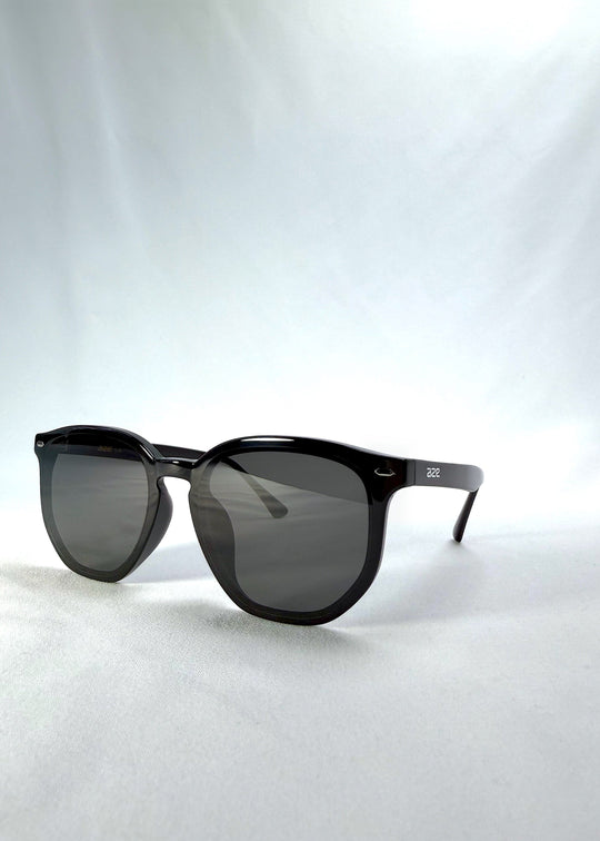 Three-quarter front view of Elara sunglasses in Obsidian Black, featuring black acetate frame and dark lenses, showing the front shape and temple profile. 