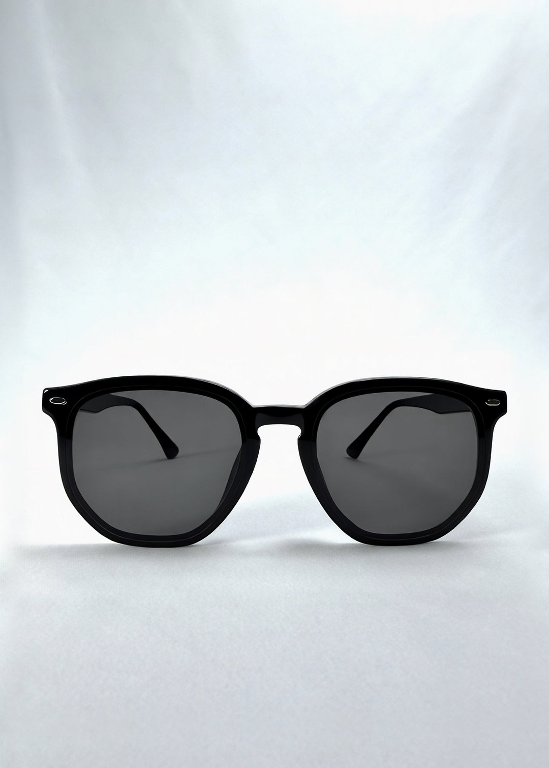 Front view of Elara sunglasses in Obsidian Black, featuring black acetate frame and dark lenses, showing the full front silhouette. 