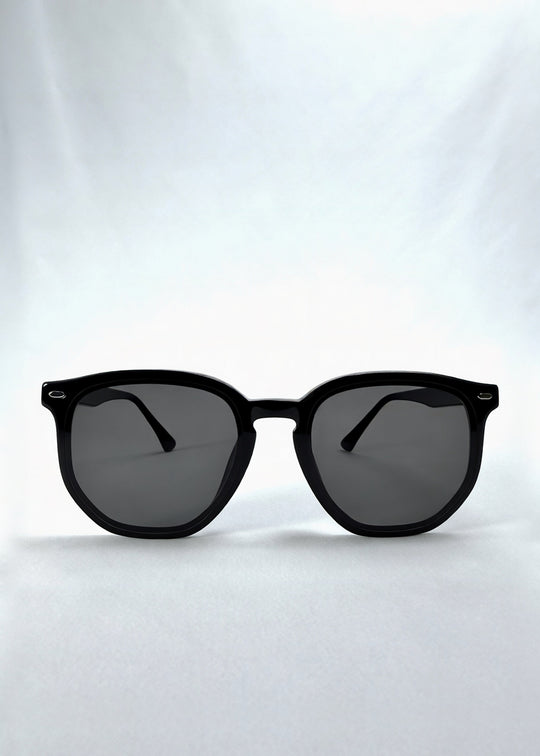 Front view of Elara sunglasses in Obsidian Black, featuring black acetate frame and dark lenses, showing the full front silhouette. 