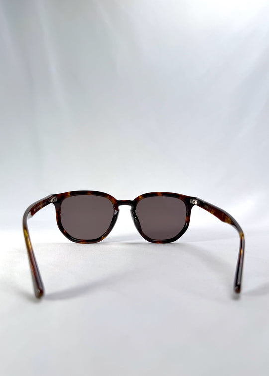 Back view of Elara sunglasses in Tortoiseshell, featuring tortoiseshell acetate frame and dark lenses, showing the inside frame and open temples. 