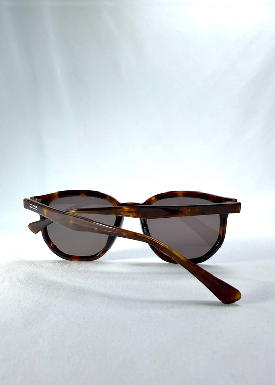 Folded view of Elara sunglasses in Tortoiseshell, featuring tortoiseshell acetate frame and dark lenses, showing the folded temples and frame profile. 