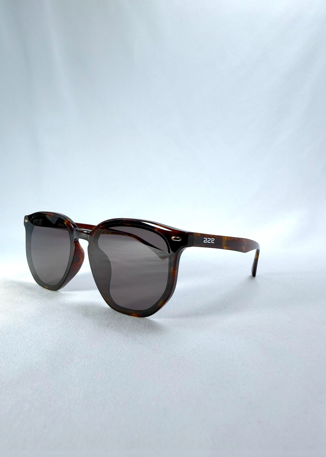 Three-quarter front view of Elara sunglasses in Tortoiseshell, featuring tortoiseshell acetate frame and dark lenses, showing the front shape and temple profile. 