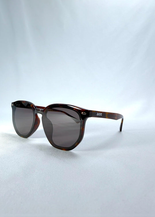 Three-quarter front view of Elara sunglasses in Tortoiseshell, featuring tortoiseshell acetate frame and dark lenses, showing the front shape and temple profile. 