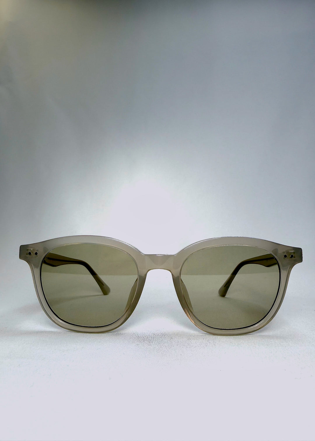 Front view of Elvor sunglasses in Glacier Smoke, featuring tea-tinted lenses and a soft grey-white frame.