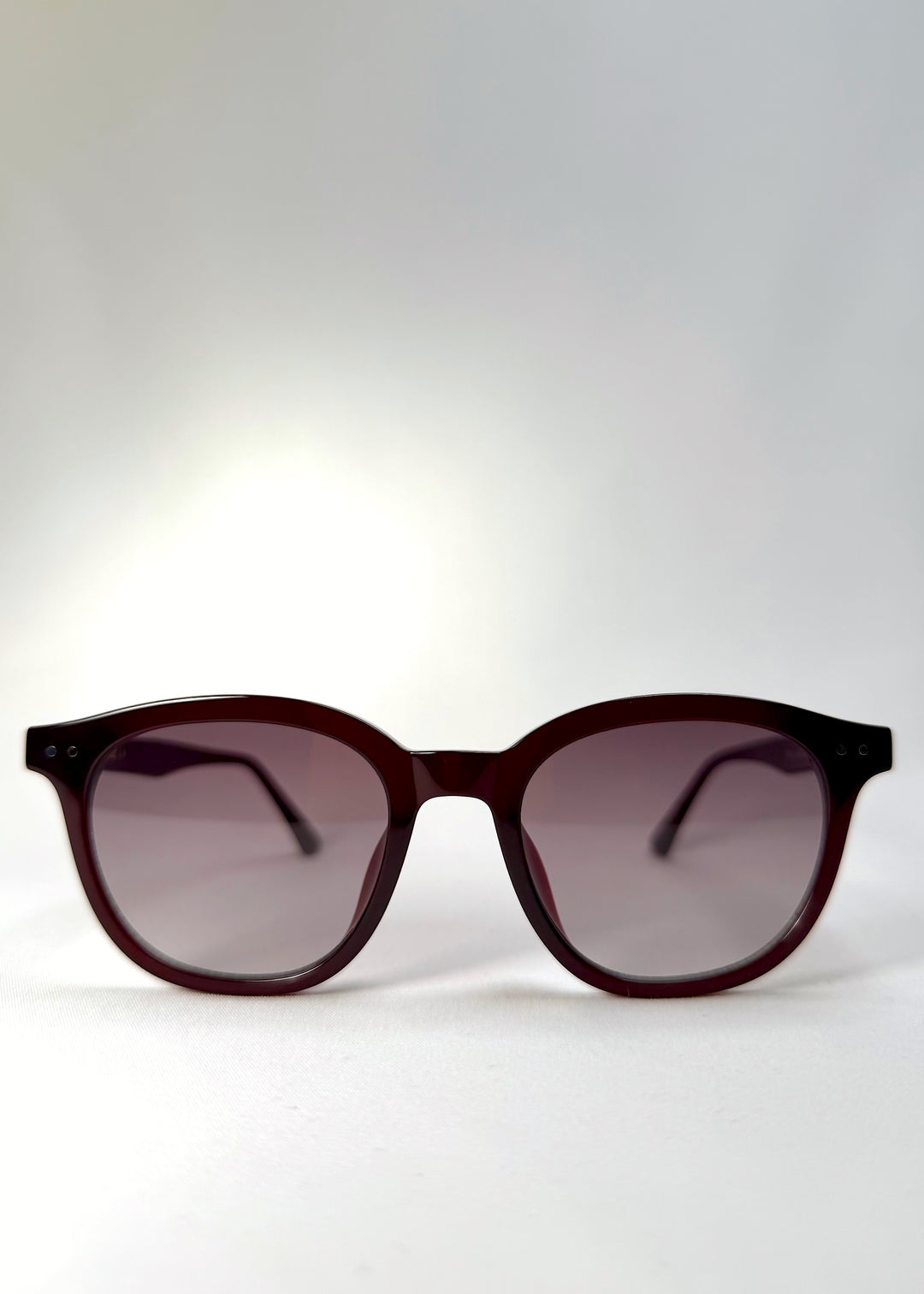 Front view of Elvor sunglasses in Mulberry Mist, featuring vintage round lenses and a translucent wine-red acetate frame.