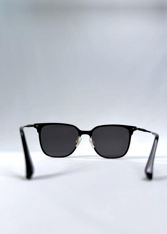 Back view of Eon Drift sunglasses in Duskgold, featuring a structured black frame, gold-tone accents, and smoky lenses, showing the inside frame and open temples.
