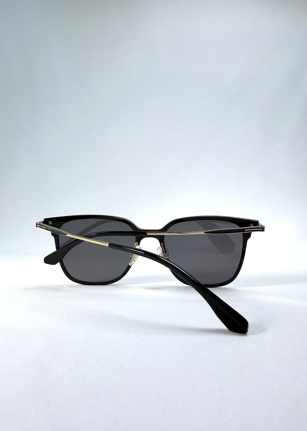 Folded view of Eon Drift sunglasses in Duskgold, featuring a structured black frame, gold-tone accents, and smoky lenses, showing the folded temples and frame profile.