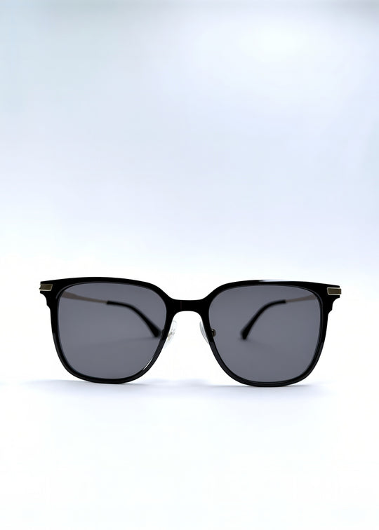 Front view of Eon Drift sunglasses in Duskgold, featuring a structured black frame, gold-tone accents, and smoky lenses, showing the full front silhouette.