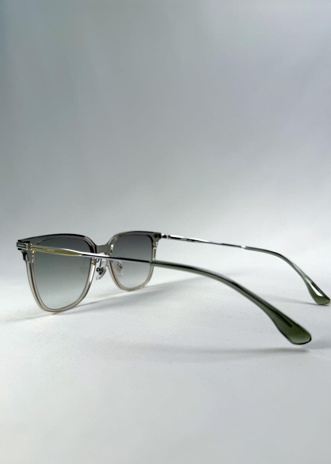 Back-angle view of Eon Drift sunglasses in Olive Shadow, featuring a translucent olive-gray frame and gray gradient lenses, showing the rear frame structure and temple alignment.