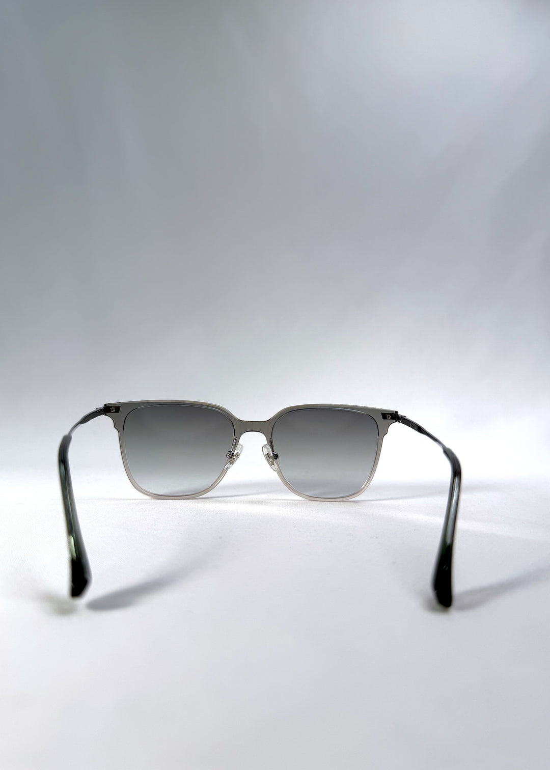 Back view of Eon Drift sunglasses in Olive Shadow, featuring a translucent olive-gray frame and gray gradient lenses, showing the inside frame and open temples.