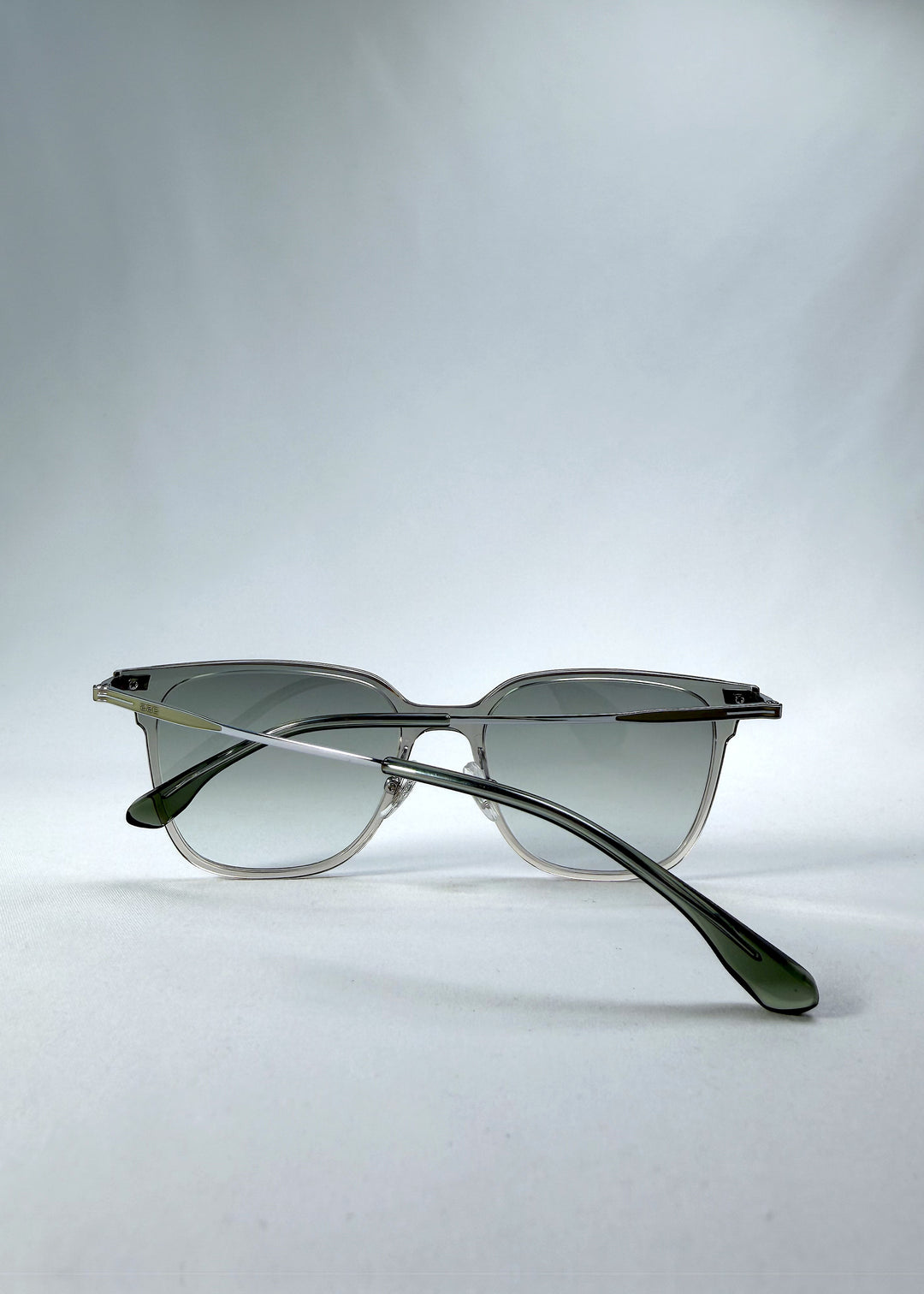 Folded view of Eon Drift sunglasses in Olive Shadow, featuring a translucent olive-gray frame and gray gradient lenses, showing the folded temples and frame profile.
