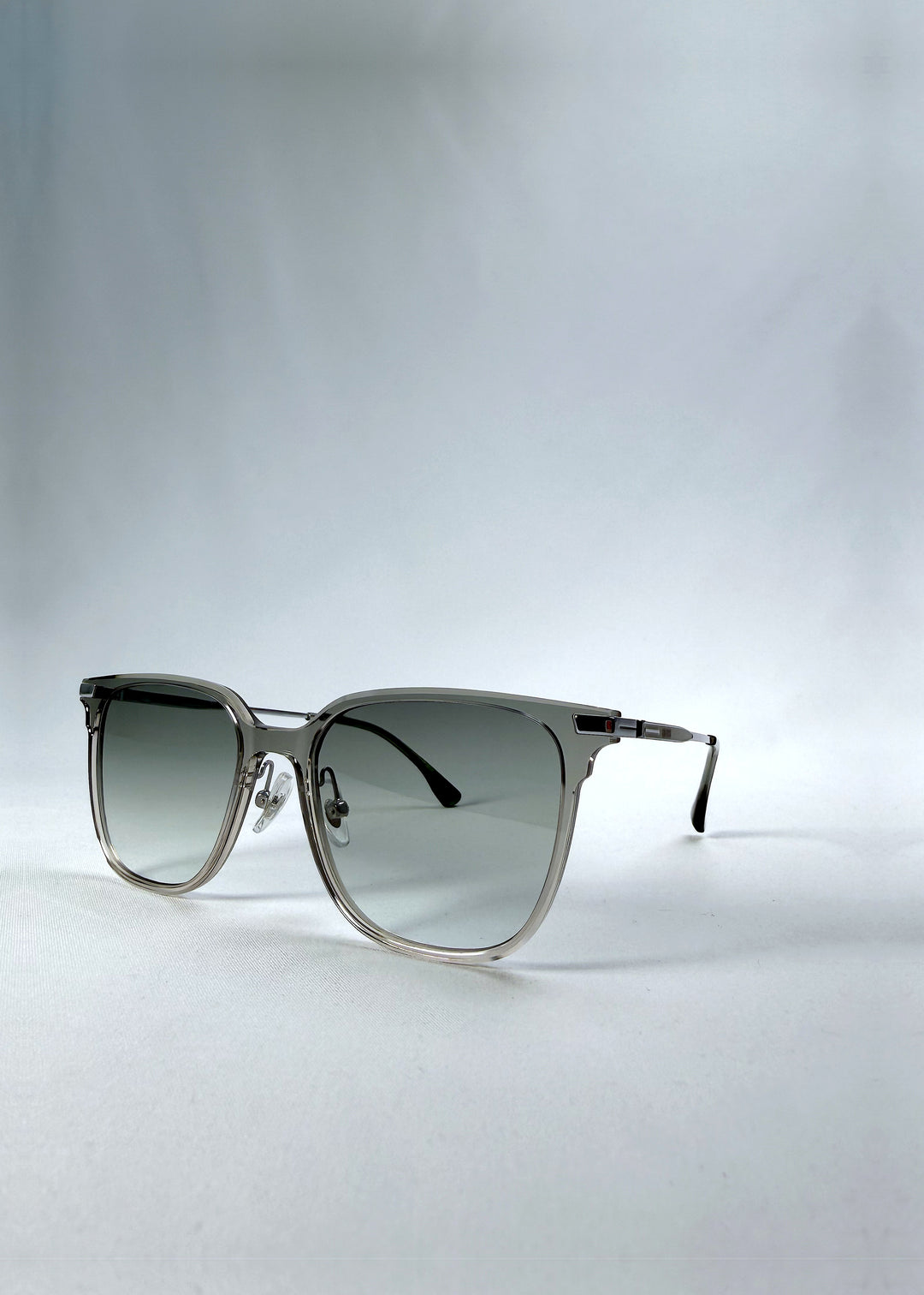 Three-quarter front view of Eon Drift sunglasses in Olive Shadow, featuring a translucent olive-gray frame and gray gradient lenses, showing the frame shape and temple profile.