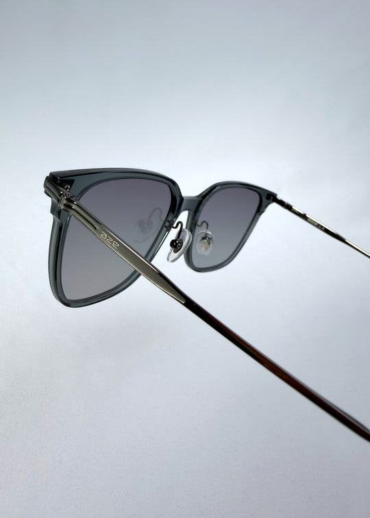 Close-up hinge detail view of Eon Drift sunglasses in Onyx Fade, featuring a dark onyx frame and gray gradient lenses, showing the hinge construction, lens edge, and temple connection.