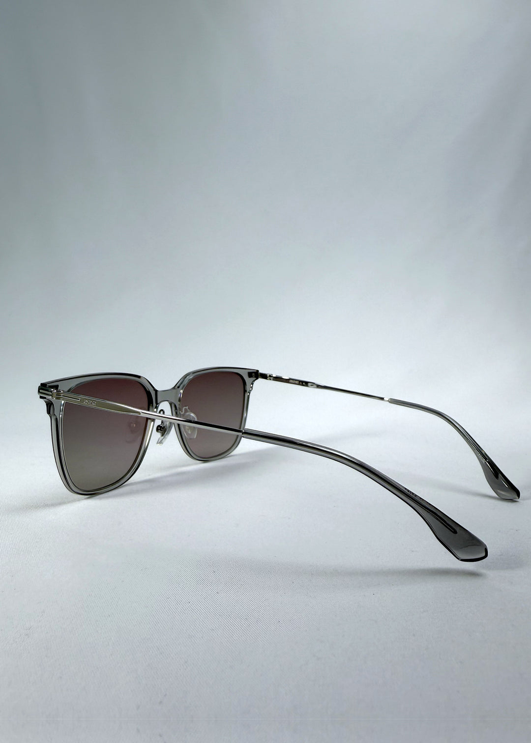 Back-angle view of Eon Drift sunglasses in Rose Graphite, featuring a rose-gray frame and smoky gradient lenses, showing the rear frame structure and temple alignment.