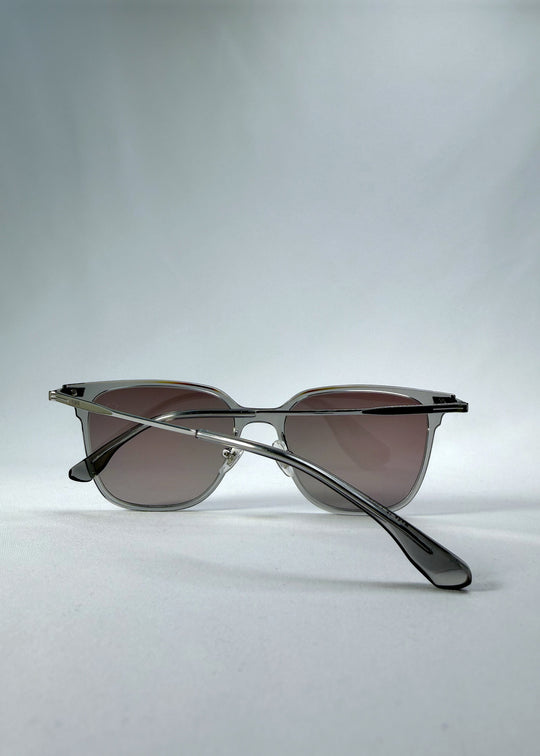 Folded back view of Eon Drift sunglasses in Rose Graphite, featuring a rose-gray frame and smoky gradient lenses, showing the rear frame and crossed folded temples.