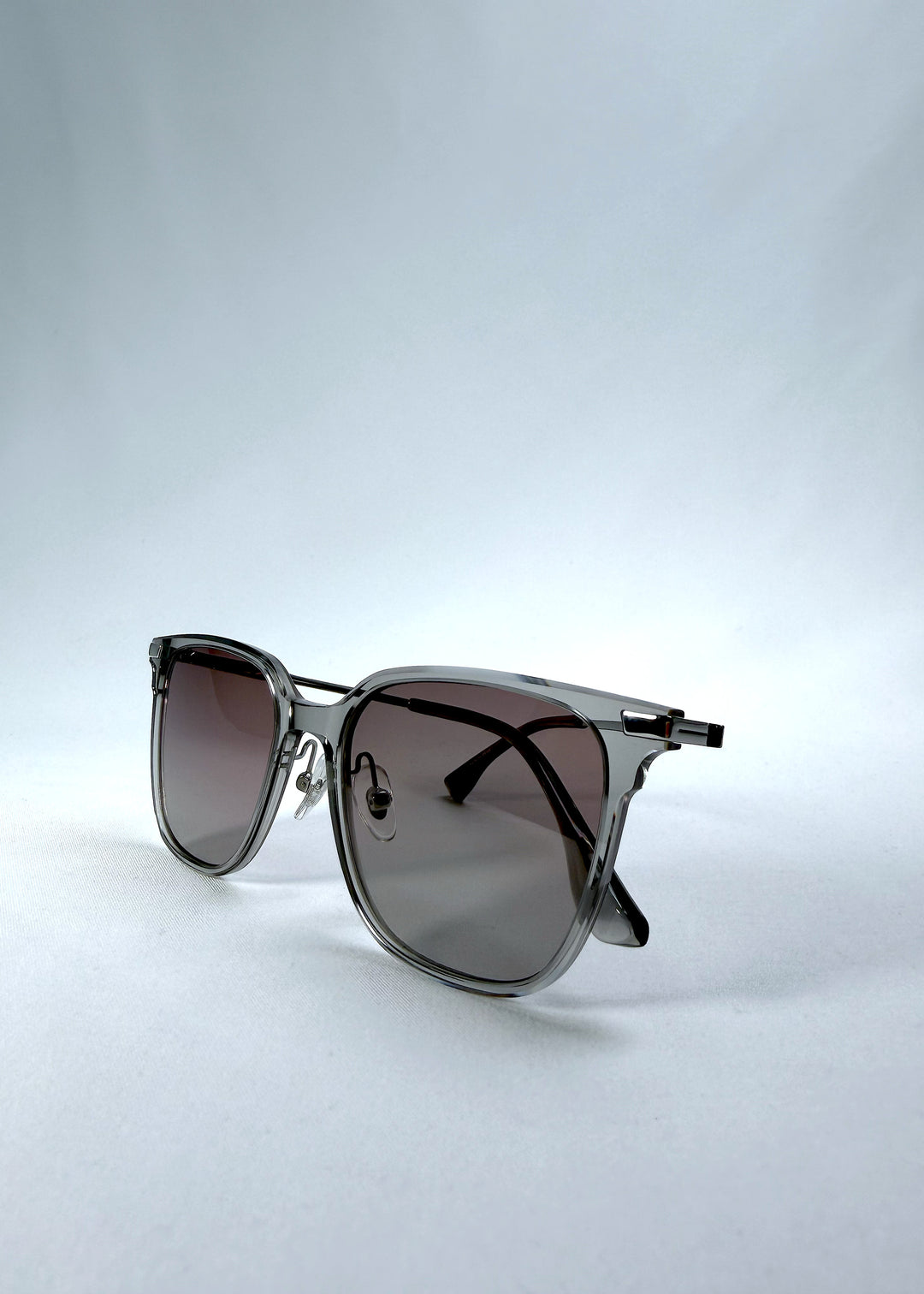 Folded front view of Eon Drift sunglasses in Rose Graphite, featuring a rose-gray frame and smoky gradient lenses, showing the front frame and folded temples.