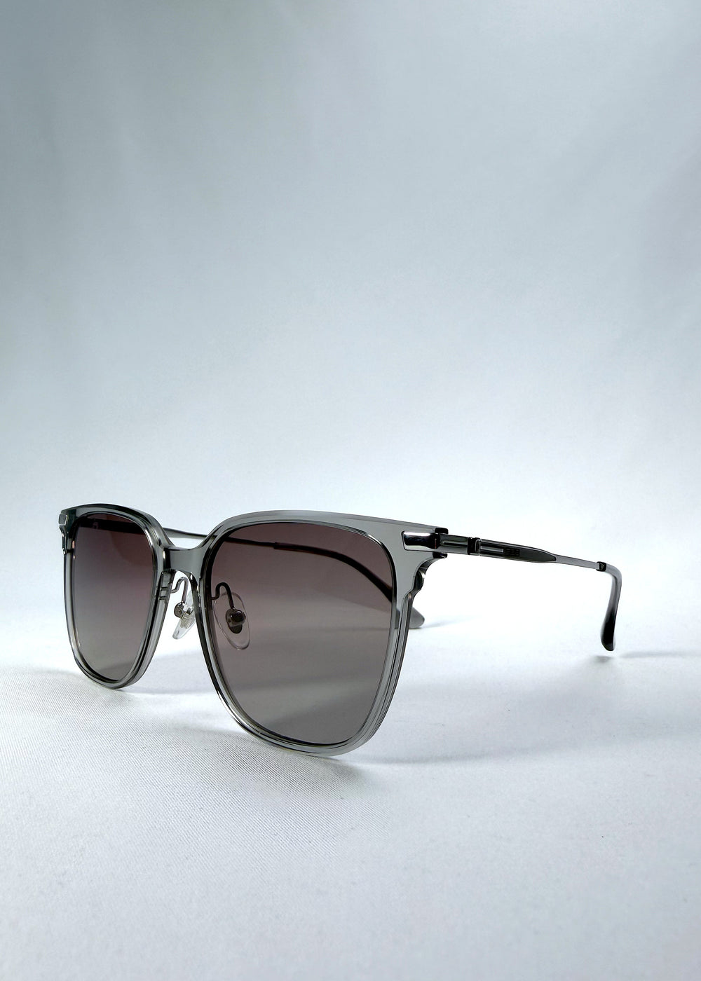 Three-quarter front view of Eon Drift sunglasses in Rose Graphite, featuring a rose-gray frame and smoky gradient lenses, showing the frame shape and temple profile.