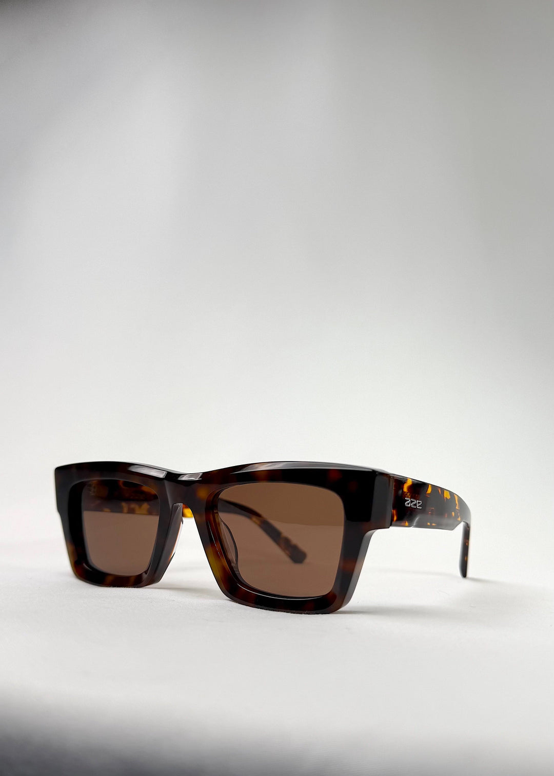 Angled close-up of Fomalhaut tortoiseshell sunglasses showcasing intricate acetate texture. 