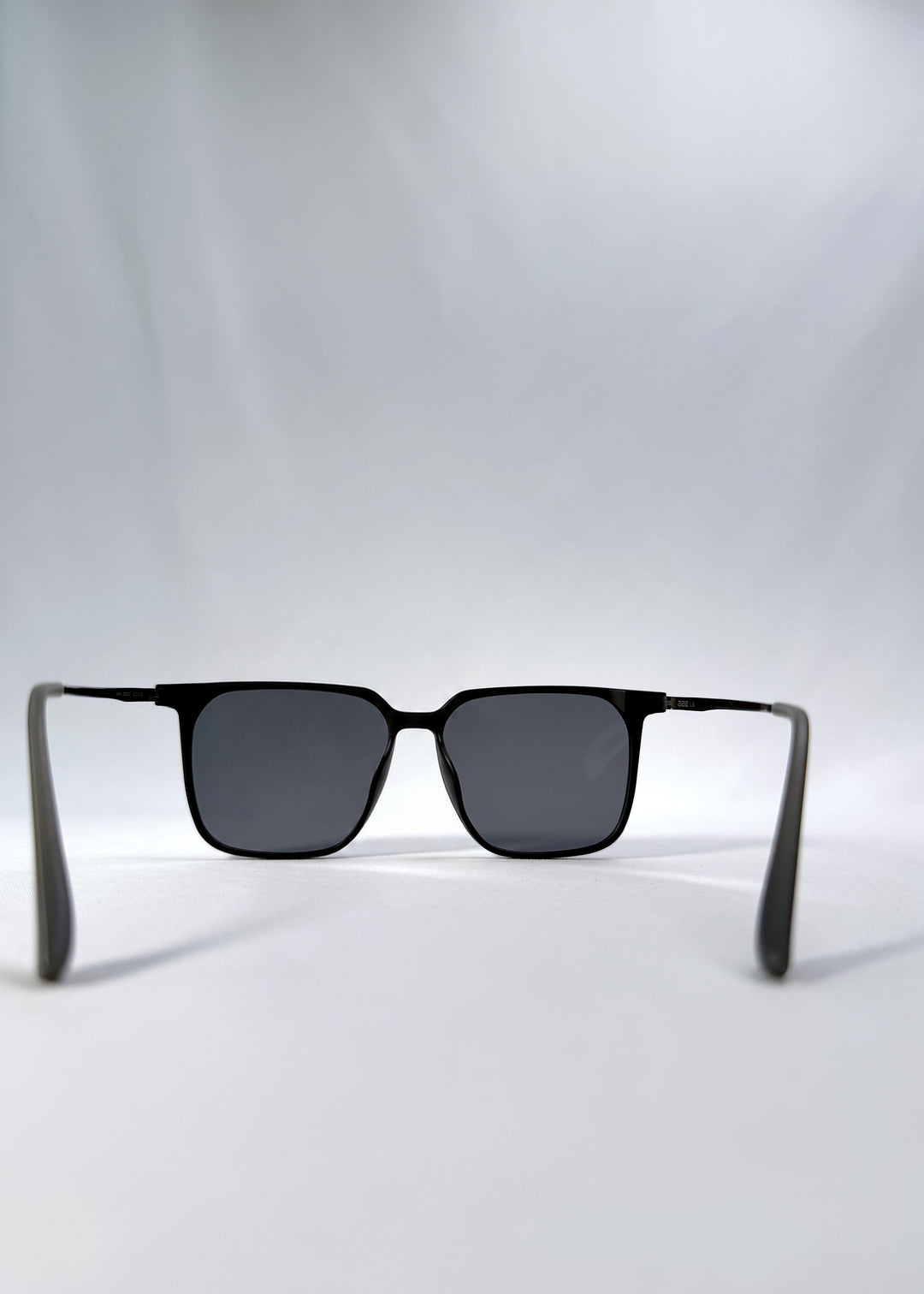 Back view of Gemini sunglasses in Matte Black, featuring light titanium frame, squared lens shape, and polarized lenses, showing the inside frame and open temples.