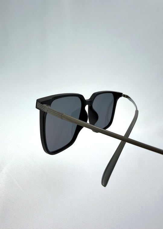 Close-up temple detail view of Gemini sunglasses in Matte Black, featuring light titanium frame, squared lens shape, and polarized lenses, showing the temple arm and hinge area.