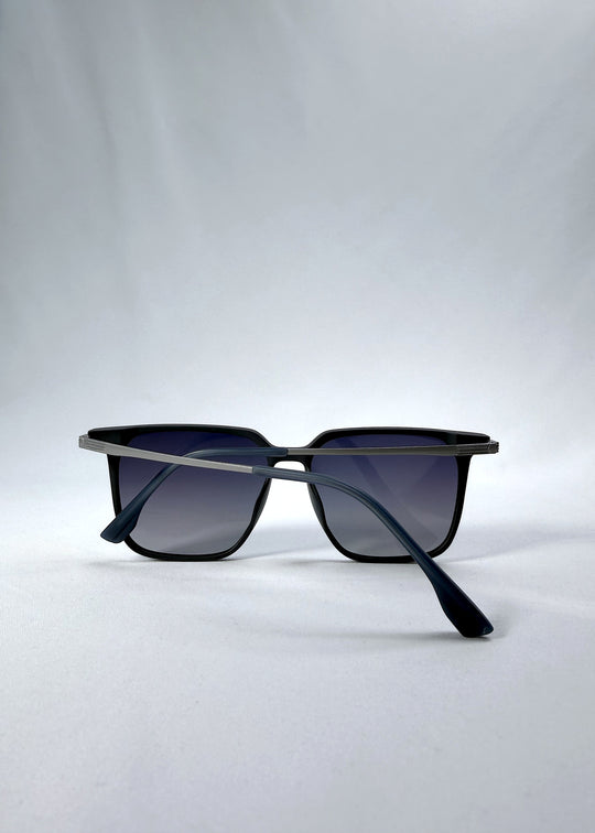 Folded view of Gemini sunglasses in Matte Blue, featuring light titanium frame, squared lens shape, and polarized lenses, showing the folded temples and frame profile.